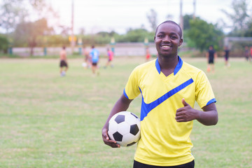 African man holding football with smile and happy.