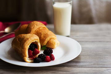 croissant on a large white plate on wooden table