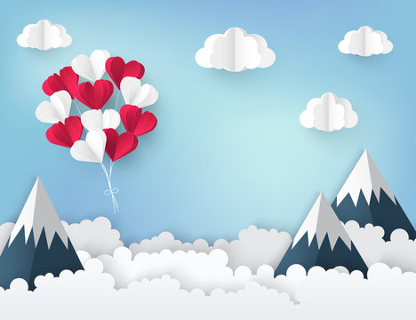 Modern paper art origami background. Bunch of red and white paper heart balloons, fluffy clouds, high mountains and place for text. Valentine's day, wedding invitation