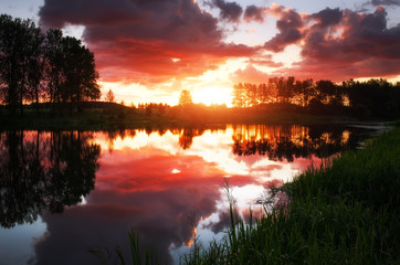 Fototapeta premium Beautiful landscape with fiery sunset over the lake. View from the coast