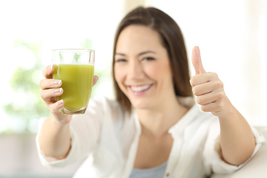 Proud woman showing a vegetable juice