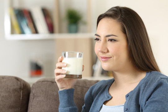 Relaxed woman holding a glass of milk at home