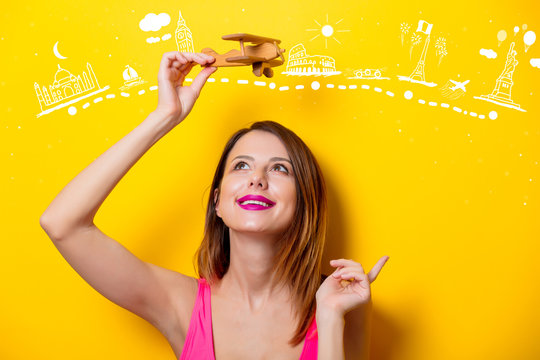 girl holding wooden toy airplane on travel attraction