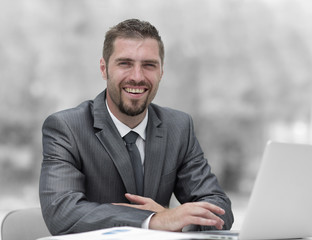 closeup.smiling businessman working with laptop