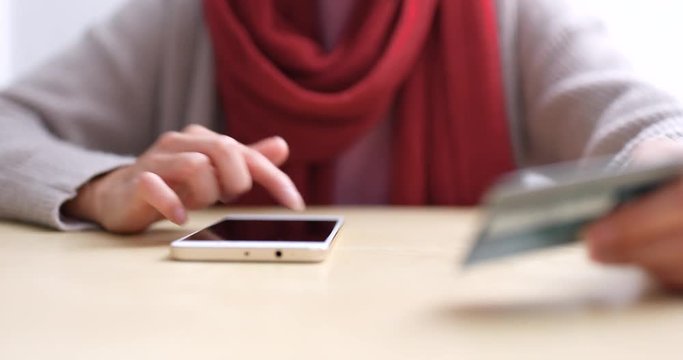 Woman using cellphone for online shopping with credit card