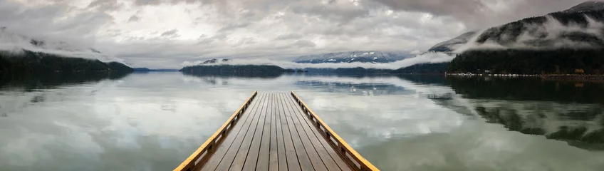 Fotobehang Wooden Dock on Harrison Lake, British Columbia, Canada. A dock appears to be heading out to nowhere on a lake in the Pacific Northwest. Harrison Hot Springs Resort. © LoweStock