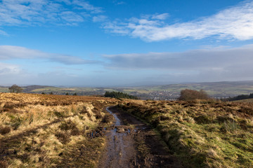 Fototapeta na wymiar Looking along a wet trail towards a small Scottish village 