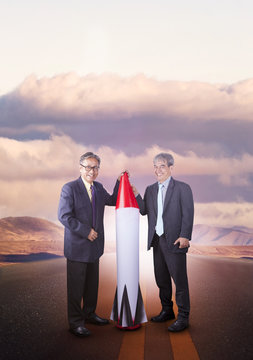 couples of asian business man with rocket missile standing on countryside highway ,conceptual for business strategy target