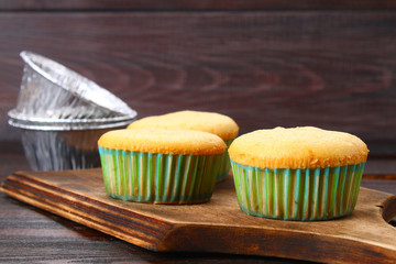 Ready baked muffins on a wooden table.