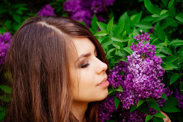 Naklejka premium portrait of young beautiful woman, lilac bloom in spring, girl outdoors in the Park