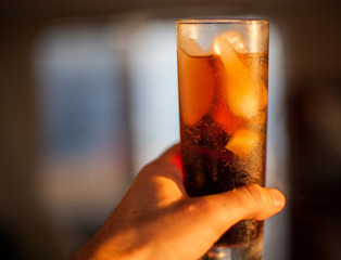  Hand with a glass of rum with cola,  A cool drink! Summer Cocktail