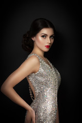 beauty fashion portrait of a beautiful model in an evening dress embroidered with stones. Girl on a...