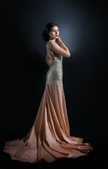 beauty fashion portrait of a beautiful model in an evening dress embroidered with stones.