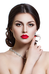 Portrait of a beautiful young woman with a professional make-up on a white background. The ideal beauty. Red lips.