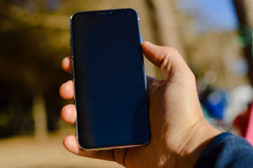 Closeup on person using mobile phone on sunny day outdoors, telecommunications lifestyle background