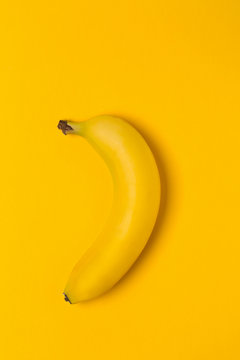 Single fresh, yellow, ripe banana on yellow