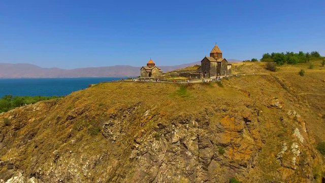 Tourists walking near ancient Surp Arakelots and Astvatsatsin churches, Armenia