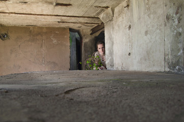 woman in vintage dress in old concrete bunker