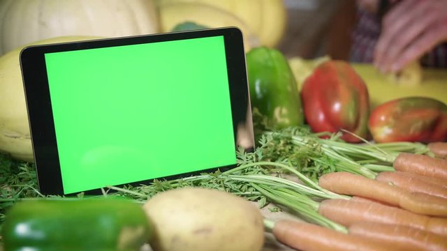 Green Screen Tablet by Healthy Organic Local Food Prepared in Background