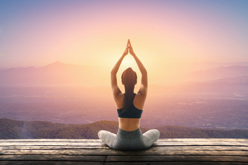 Young woman is practicing yoga at mountain