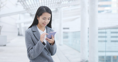 Obraz premium Businesswoman sending sms on cellphone at outdoor