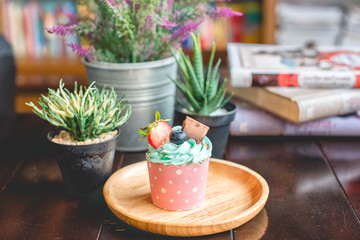 Cupcake strawbery with cream and chocolate  stick on the wood dish, grain, Blueberry, Selective focus