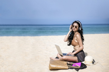 woman relax in vacation using laptop computer on the beach. Freelance work concep