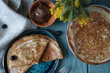 Thin pancakes on a plate on a table