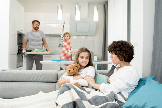 Portrait of happy young family with two children enjoying quiet weekend at home in modern apartment