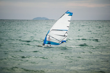 windsurfer floating on board at sea.