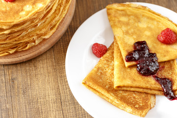 Thin pancakes on a table and on a plate