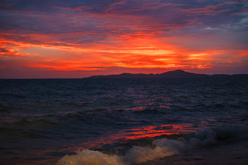 red sunset on the beach. Beach with waves at dusk.