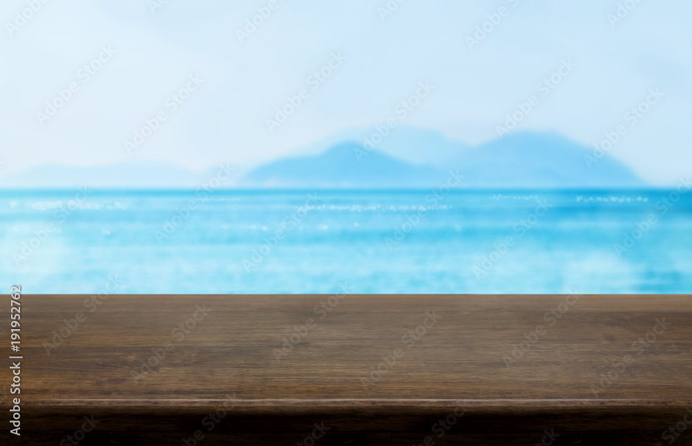 Poster empty old dark wood table top with blur blue sky and sea bokeh background,mock up template for displ