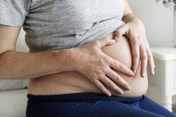 Pregnant woman sitting on the bed