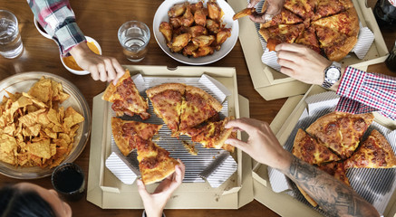 Friends eating pizza together at home