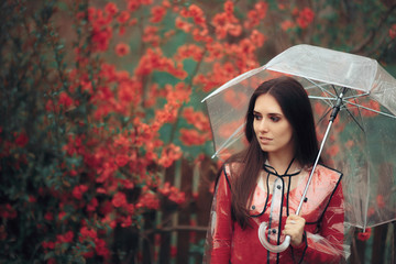 Beautiful Woman with Transparent Raincoat and Umbrella Enjoying Rain