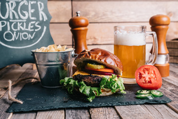 .Cheeseburger on a Pretzel Bun With Cold Craft Beer