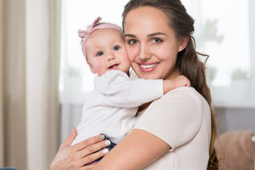 A young mother plays with a baby.