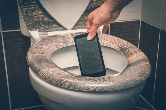 Woman Throwing Mobile Phone In The Toilet Bowl