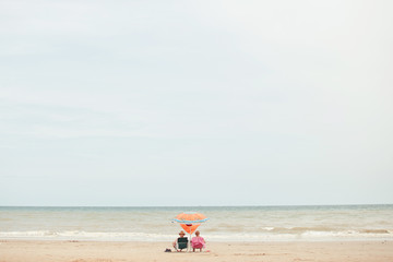 Fototapeta na wymiar two people sit in a hammock on the beach against the sea.