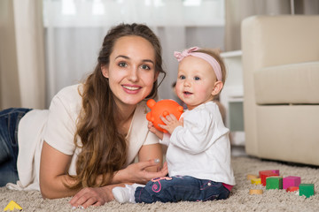 Naklejka premium A young mother plays with a baby.