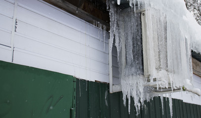 icicles hanging from the air conditioner close-up. frozen air conditioning on the building