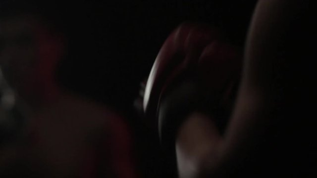 Boxers begin a training fight. The background is blurry. Sharpness in the foreground. Shooting in a dark key.