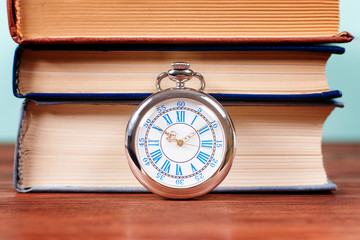 Old pocket watch with old books