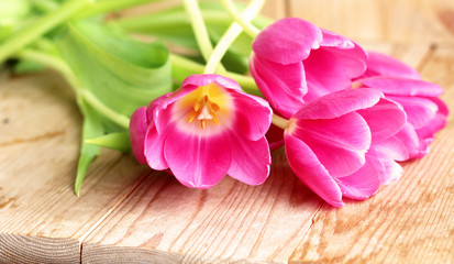 Bouquet of pink tulips over wooden table. Spring greeting card happy mother day copy space.