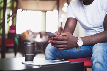 Attractive African businessman using smartphone.Concept of young people working mobile devices.Closeup with a selected focus.