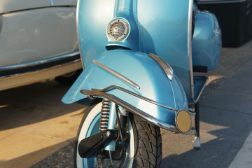 Recycled retro blue motorcycle. Front fender and wheel.