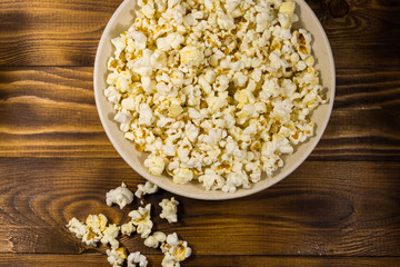 Bowl with popcorn on wooden table