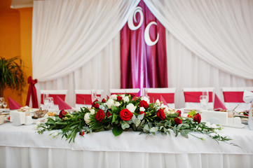 Wedding table decorated with red roses in the restaurant.