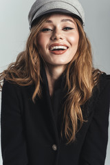 Fashion portrait of a laughing stylish curly brown haired woman